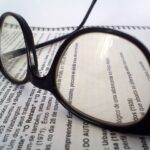 Image of glasses and a report for an article about How To Get the Most From Your Spend Analysis Reports.